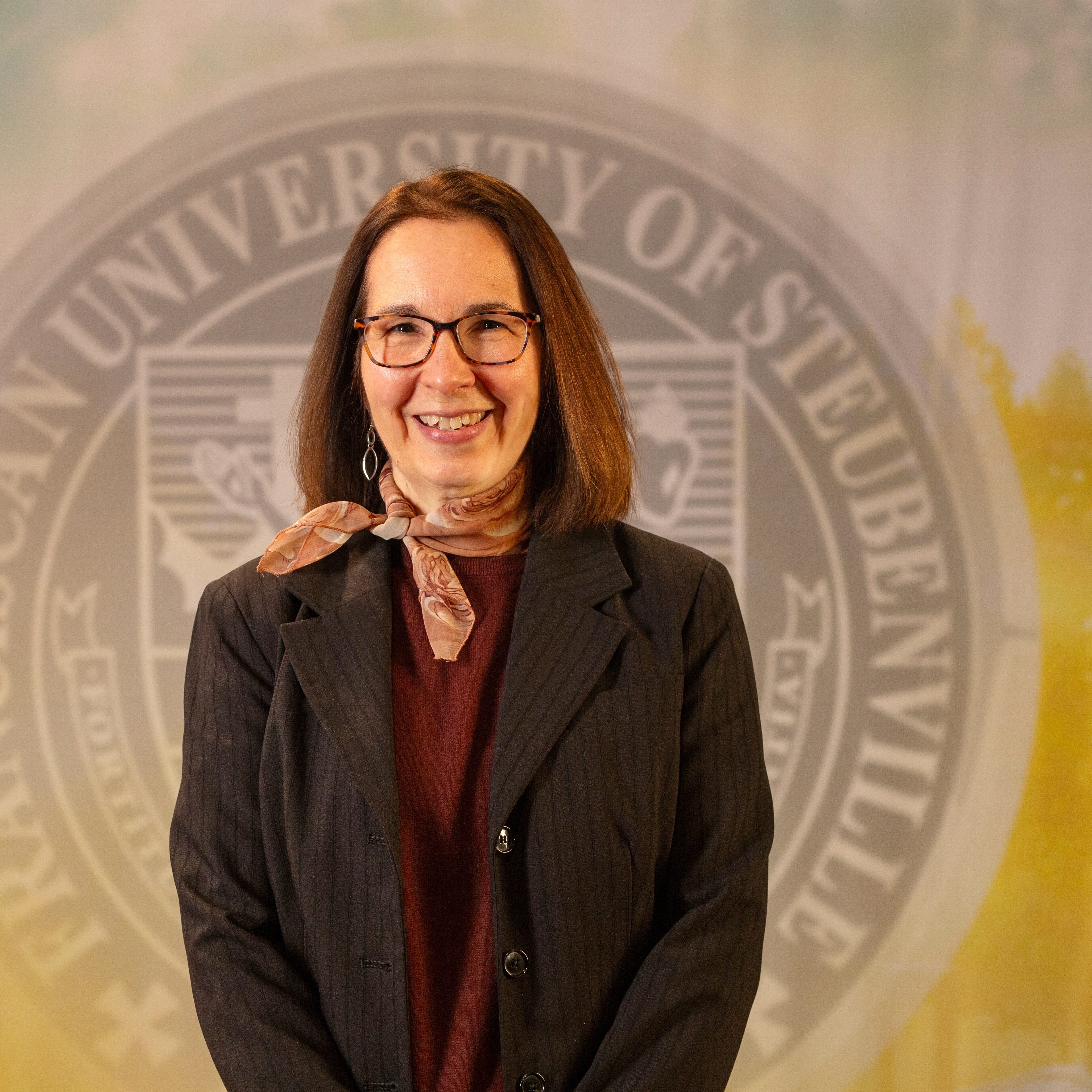 Dr. Monica Anderson standing in front of a university seal.