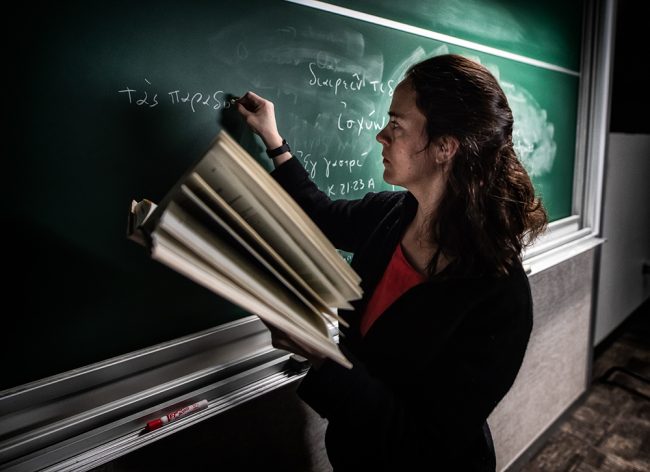Female Professor writing on chalkboard